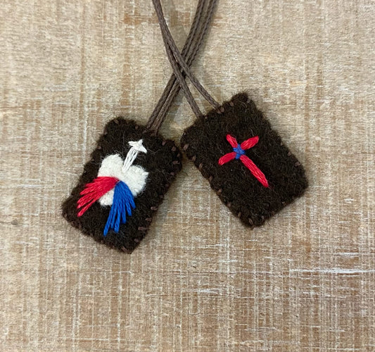 Brown Scapular featuring a red and blue cross and a white heart with a blue and red ray coming down with a with cross above the heart.