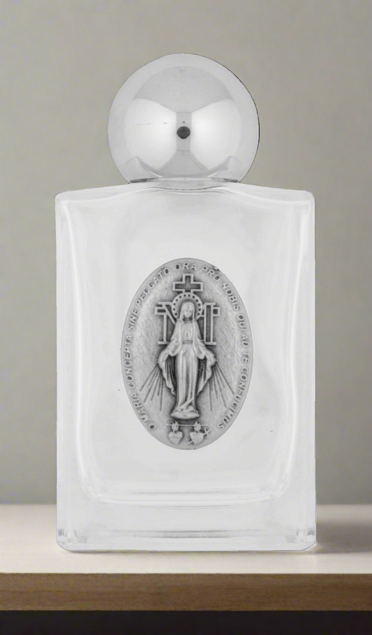 A glass holy water bottle featuring a silver Miraculous Medal.