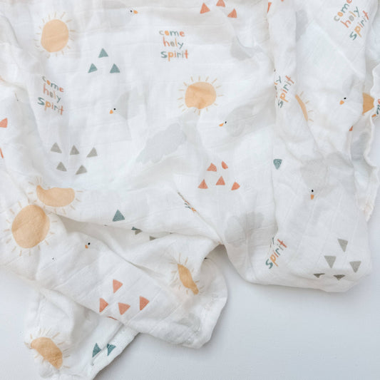 An open baby blanket in a white color featuring triangles, dove, sun and words that read "Come Holy Spirit"